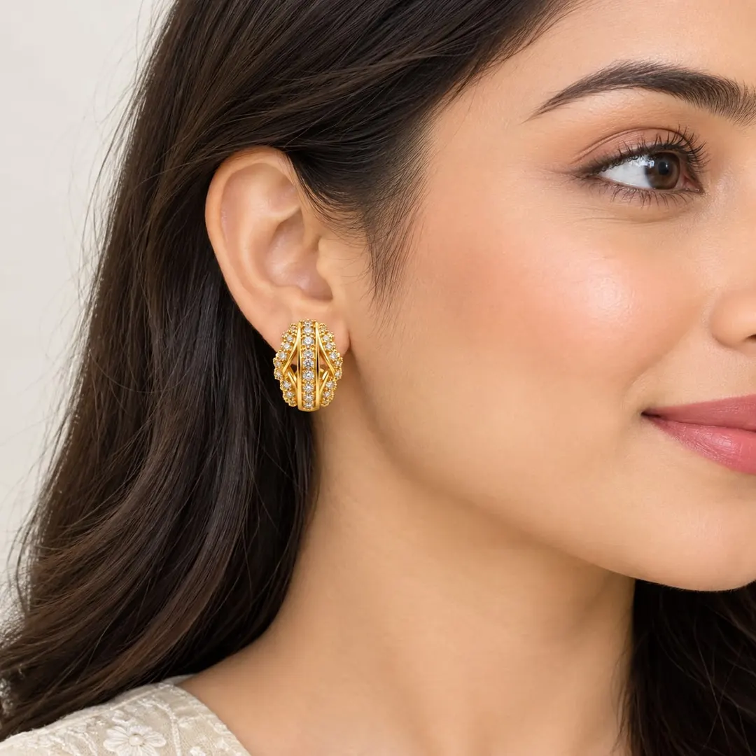 GOLD-TONE CRYSTAL-STUDDED OVAL HOOP EARRINGS.