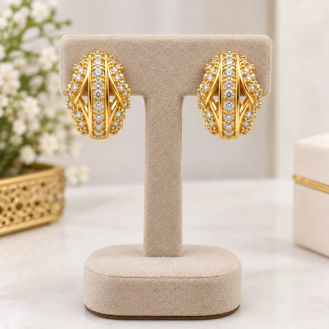 GOLD-TONE CRYSTAL-STUDDED OVAL HOOP EARRINGS.