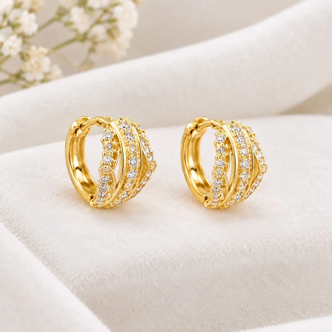 GOLD-TONE CRYSTAL-STUDDED OVAL HOOP EARRINGS.