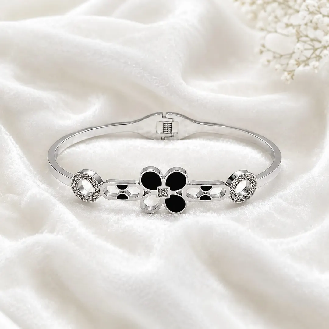 SILVER-TONE BLACK CLOVER HINGED BRACELET.