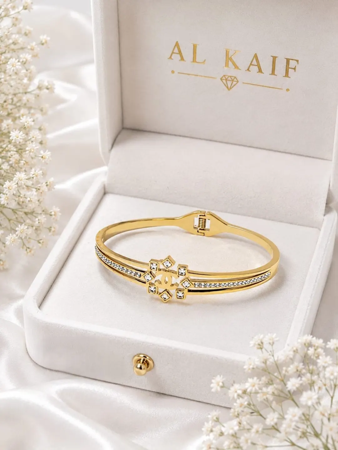 CHANEL GOLD TONE CYRSTAL EMBELLISHED HINGED BRACELET.