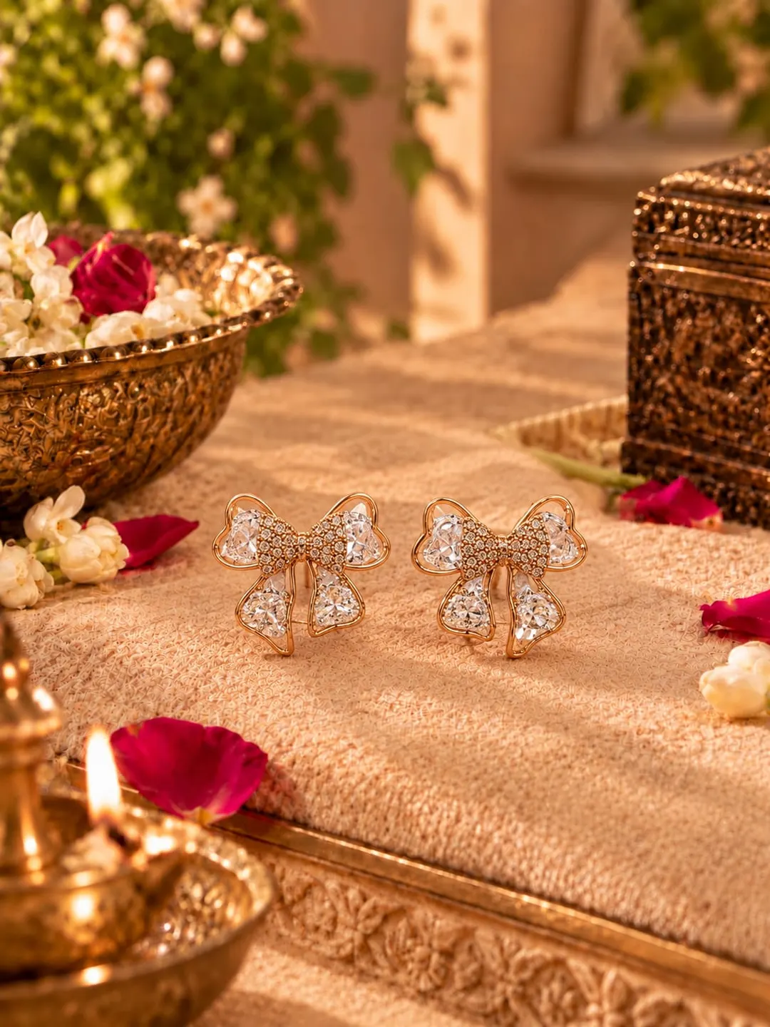 ROSE GOLD CRYSTAL BOW EARRINGS.